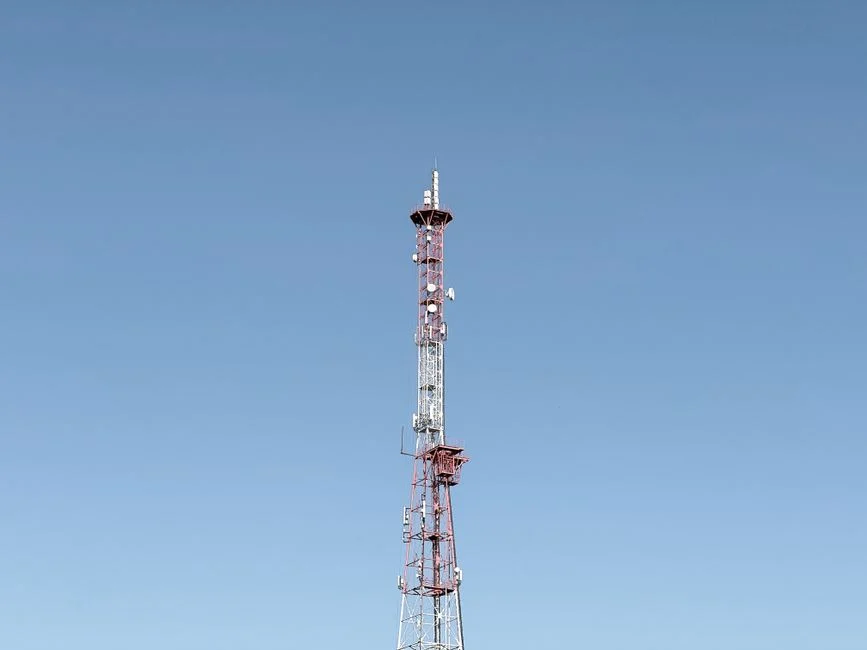 Ilustrasi seseorang sedang menggunakan smartphone dengan koneksi 5G di area perkotaan.